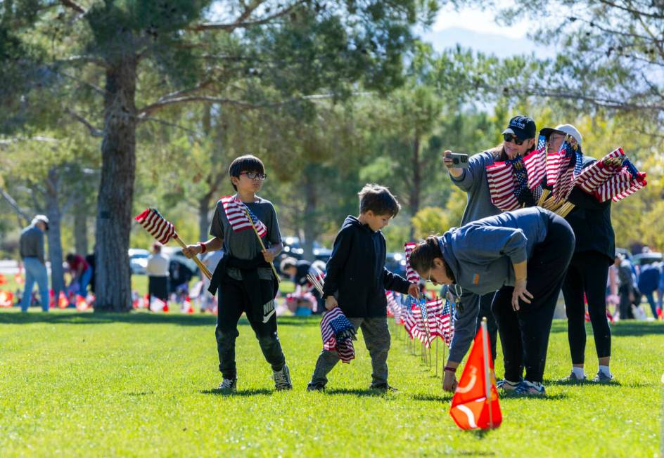 Volunteers place around 14,000 small American flags at veterans grave markers in the Southern N ...