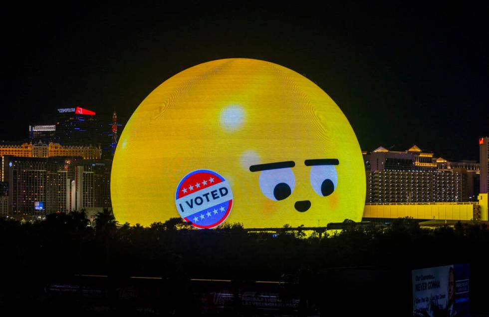 The Sphere shows a voting ad as people continue wait in a long line to cast their ballots on El ...