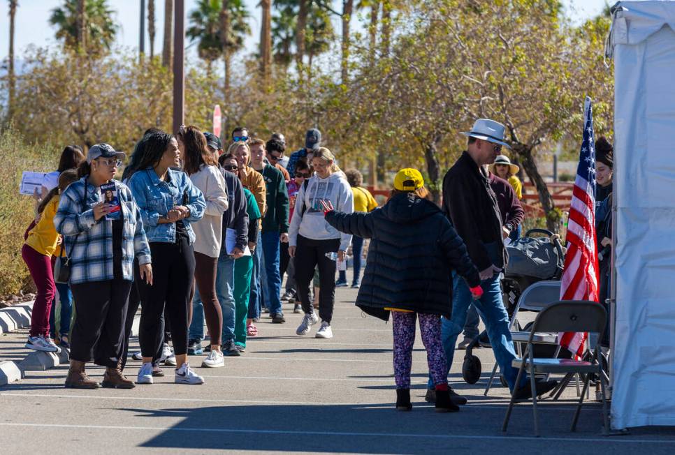 Voters wait in line to cast their ballots on the final day of early voting in the polling locat ...