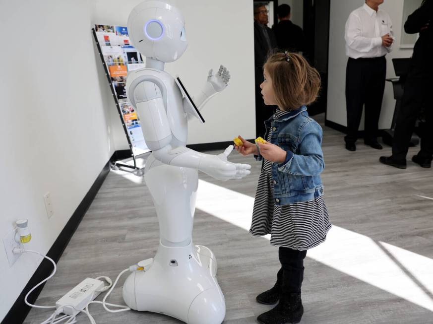 Zoey Zozaya, 3, of Henderson interacts with “Pepper” the robot during the grand o ...