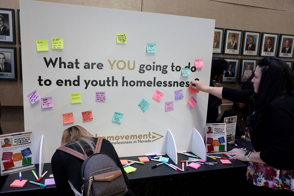 Attendees, including Melanie Gamble with CAAA Insurance Group, post notes on a display during t ...