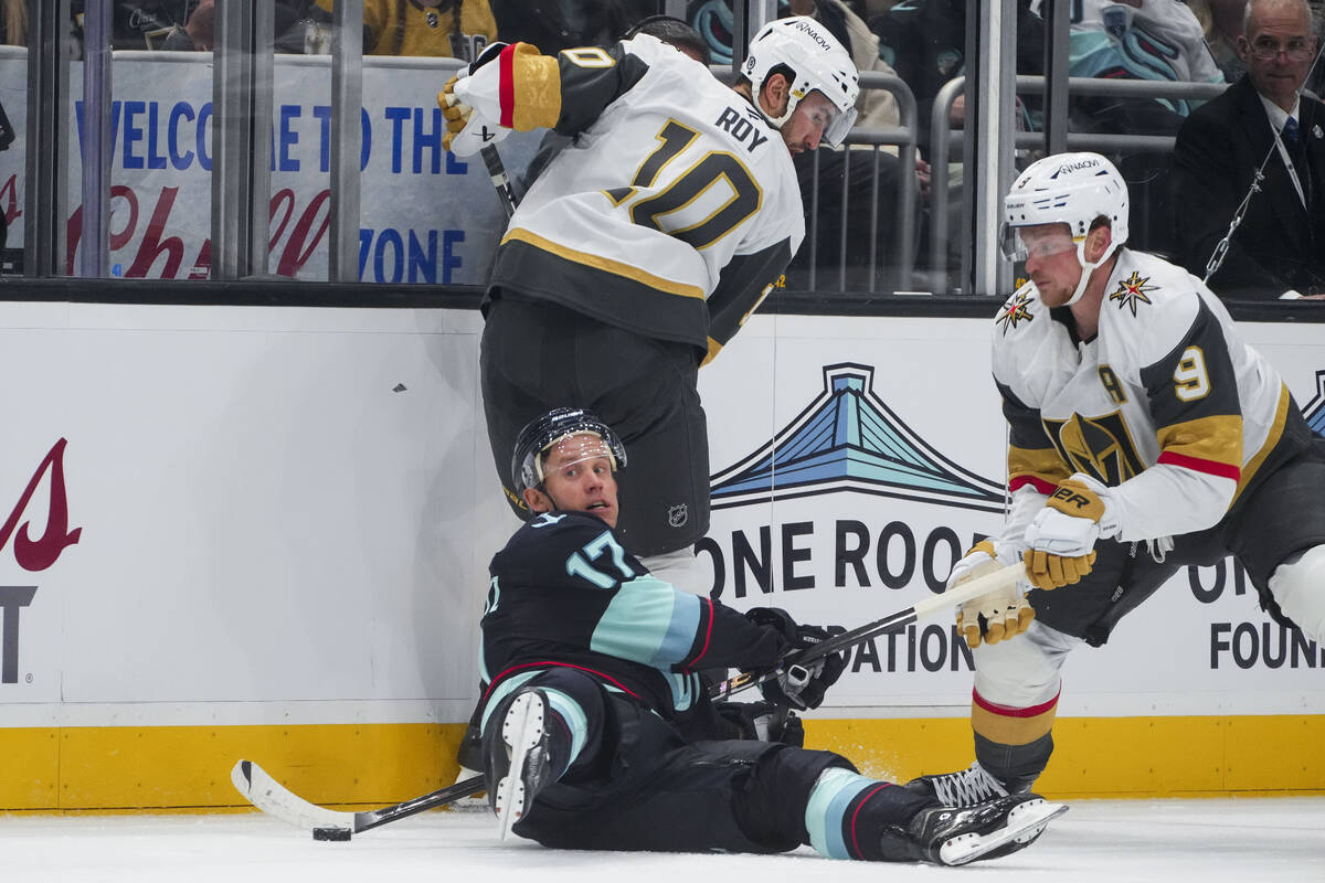 Seattle Kraken center Jaden Schwartz (17) falls against Vegas Golden Knights center Nicolas Roy ...