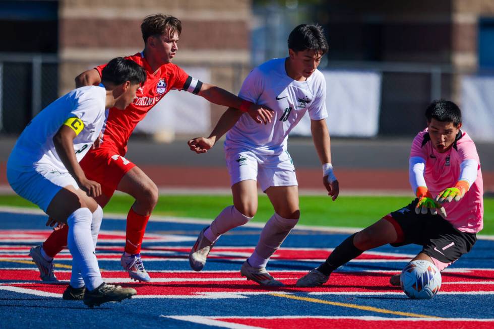 Hug goalkeeper Diego Caceres (right) makes a save during a 5A boys soccer state championship ma ...