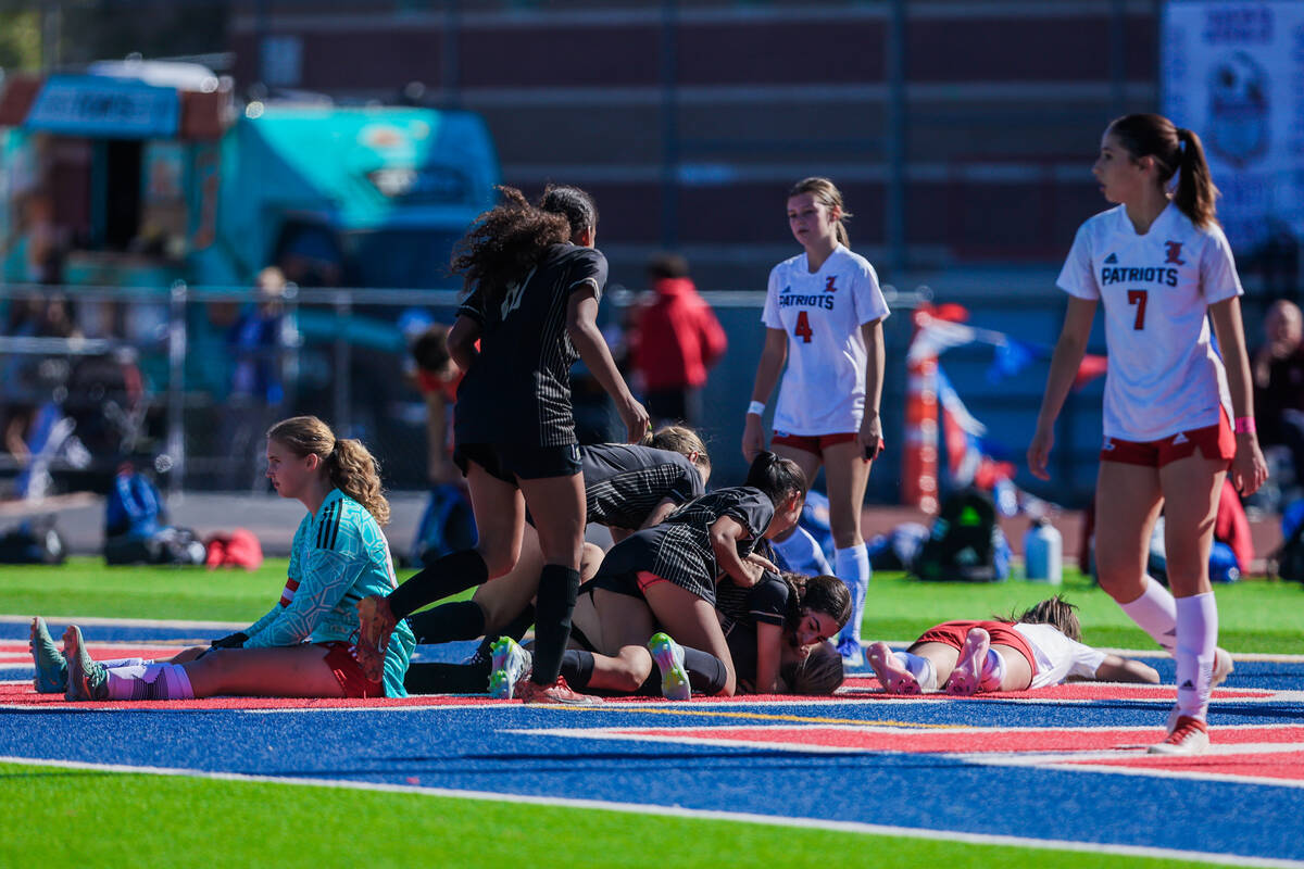 Faith Lutheran players pile onto each other to celebrate winning as Liberty goalkeeper Brooke K ...