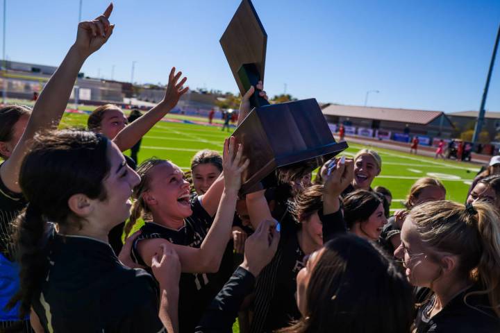 Faith Lutheran soccer players, including Julia Anfinson with trophy, celebrate after winning th ...