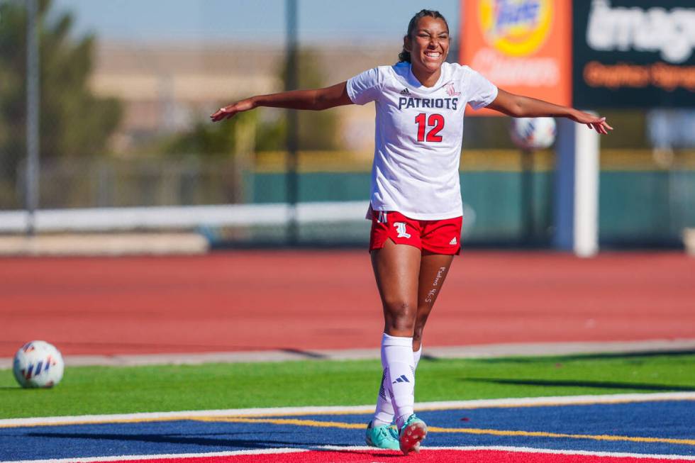 Liberty midfielder Ayva Jordan (12) smiles at her teammates on the bench during a 5A girls socc ...