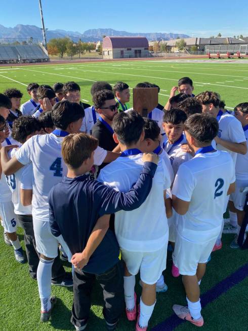 The Canyon Springs boys soccer team gathers around its trophy after winning the Class 4A state ...