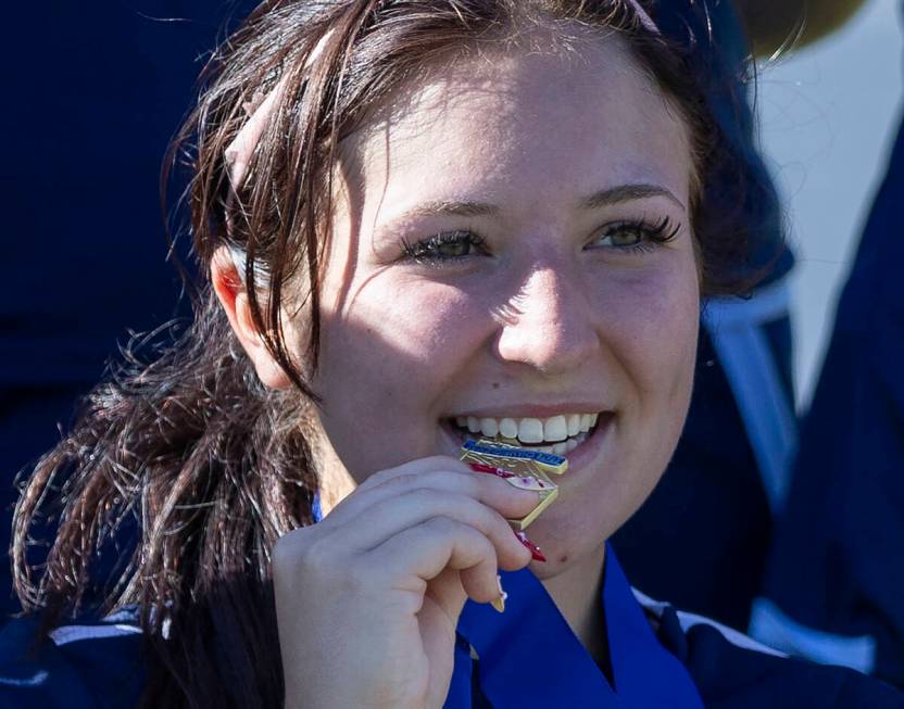 Centennial midfielder Natalie Sligar (3) bites her medal while taking a group photograph after ...