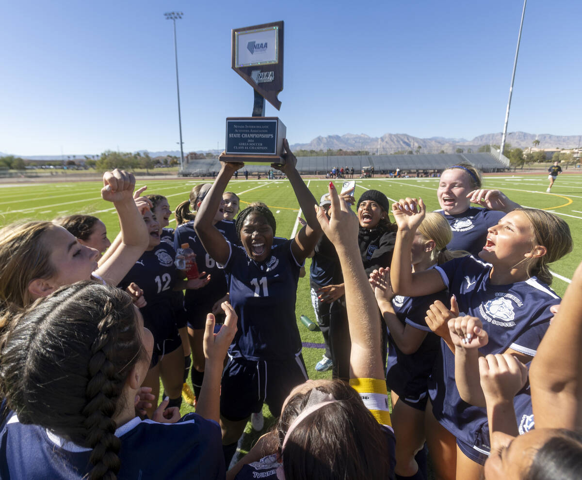 Centennial defender Natalie Penniston-John (11) holds up the trophy after winning the 4A girls ...