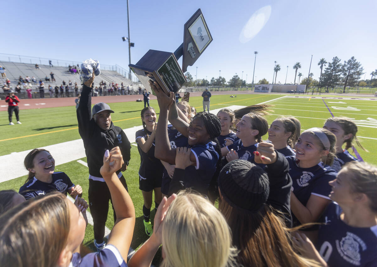 Centennial defender Natalie Penniston-John (11) holds up the trophy after winning the 4A girls ...