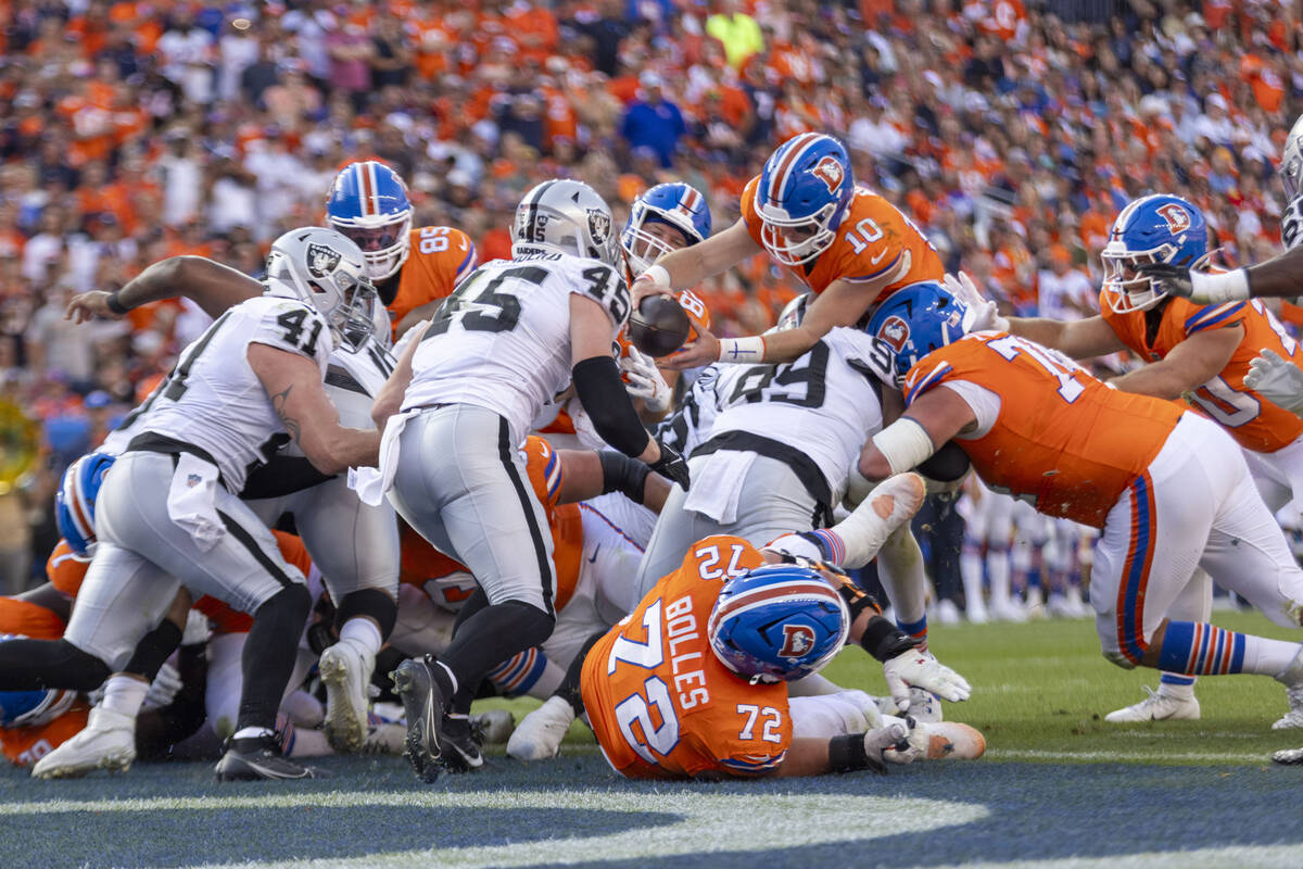 Denver Broncos quarterback Bo Nix (10) leaps overRaiders defensive tackle Nesta Jade Silvera (9 ...