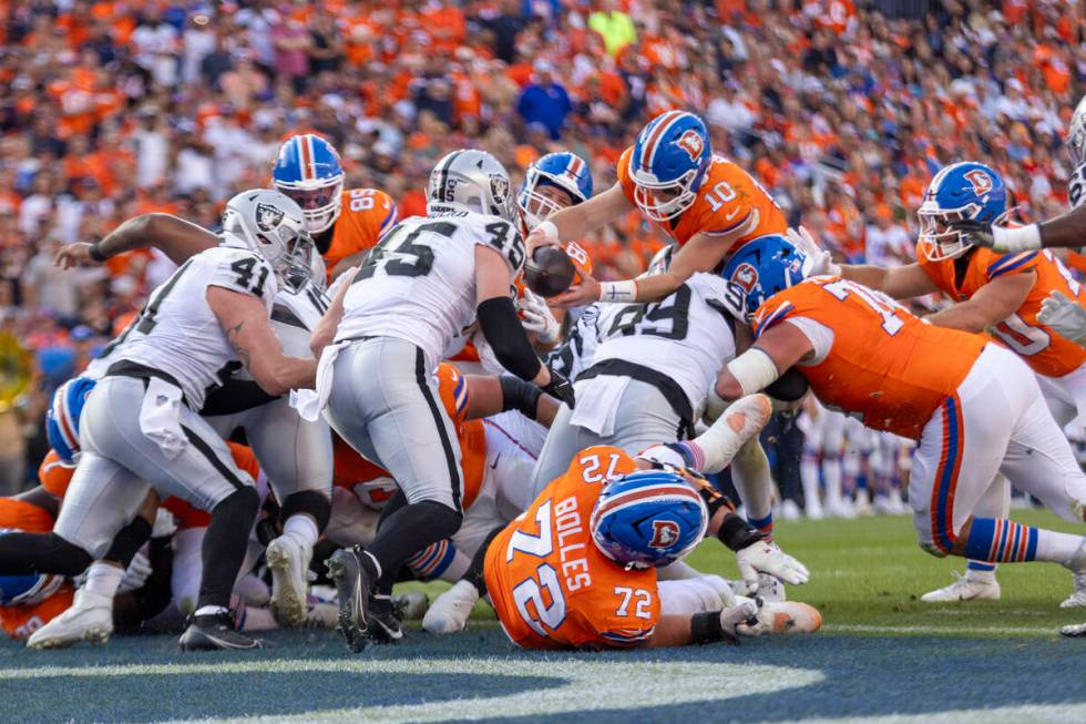 Denver Broncos quarterback Bo Nix (10) leaps overRaiders defensive tackle Nesta Jade Silvera (9 ...