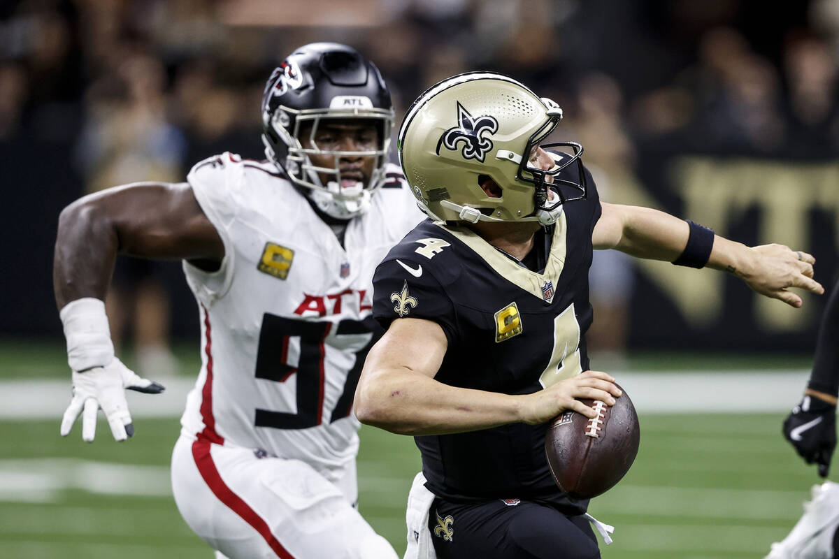 New Orleans Saints quarterback Derek Carr (4) works in the pocket under pressure by Atlanta Fal ...