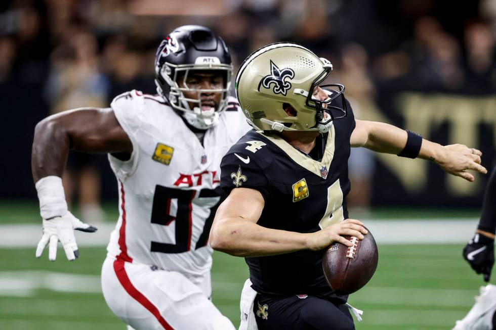 New Orleans Saints quarterback Derek Carr (4) works in the pocket under pressure by Atlanta Fal ...