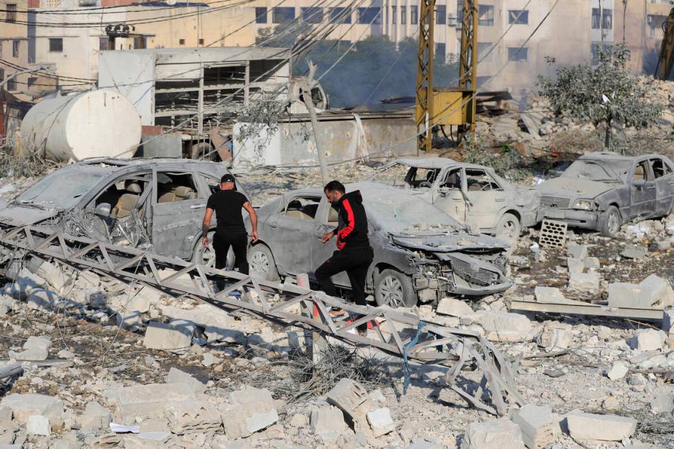 Resident check the site of an Israeli airstrike in Tyre, southern Lebanon, Saturday, Nov. 9, 20 ...