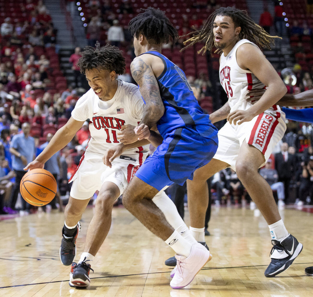 UNLV guard Dedan Thomas Jr. (11) pushes against Memphis Tigers guard PJ Haggerty (4) during the ...