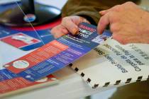 An election worker goes over a ranked choice voting explanation card with a voter. (AP Photo/Ma ...