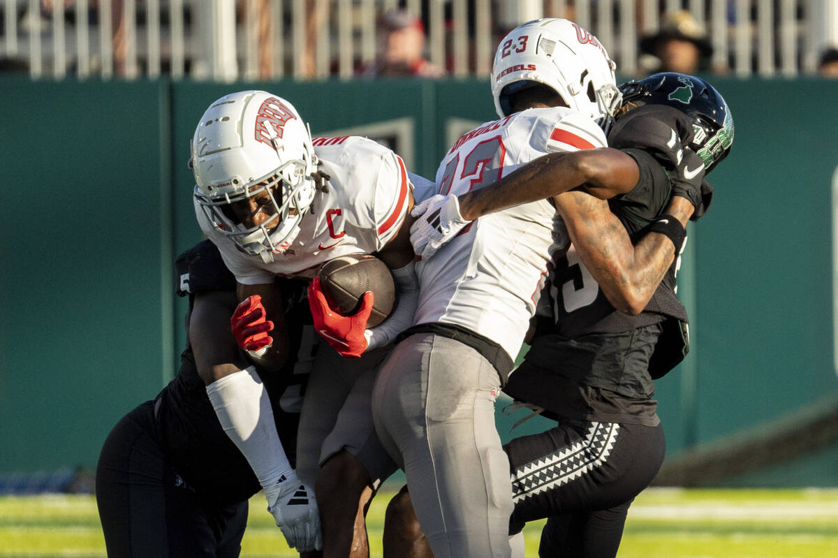 UNLV wide receiver Ricky White III (11) leaps over Hawaii defense during the first half of an N ...