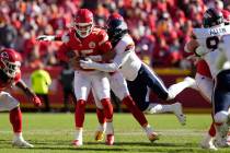 Kansas City Chiefs quarterback Patrick Mahomes (15) is stopped by Denver Broncos outside lineba ...