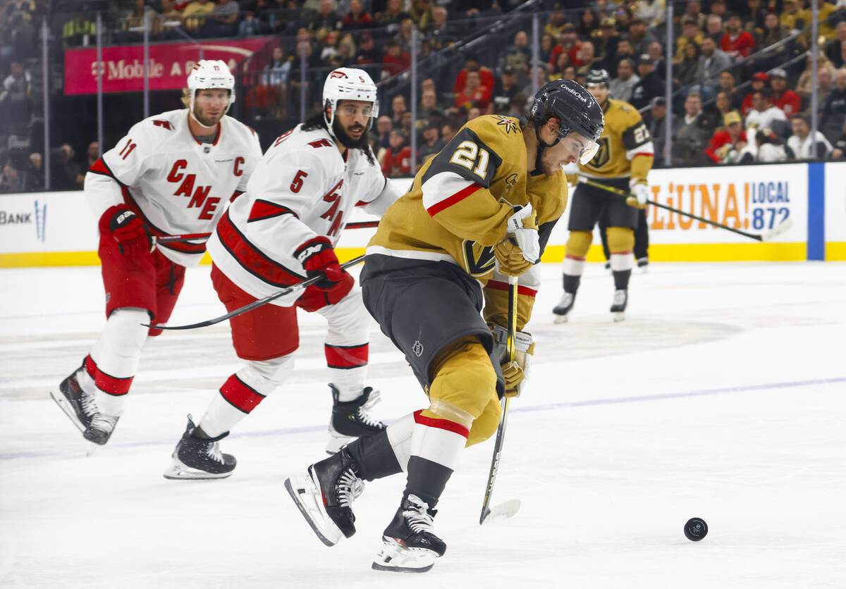 Golden Knights center Brett Howden (21) skates with the puck in front of Carolina Hurricanes de ...