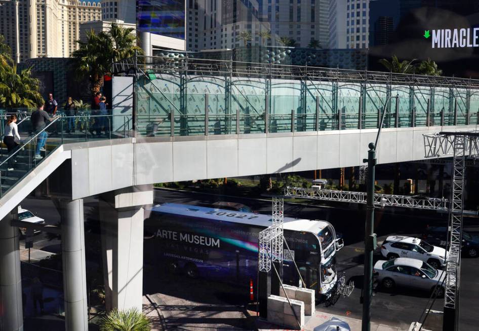 Pedestrians use the pedestrian bridge over Las Vegas Boulevard near the Cosmopolitan and Planet ...