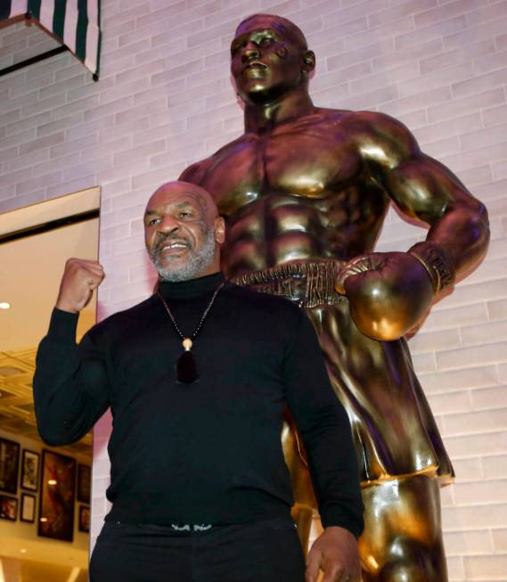 Former boxer Mike Tyson, center, poses for photos in front of newly unveiled Tyson's stature at ...