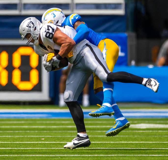 Raiders tight end Michael Mayer (87) secures a catch over Los Angeles Chargers safety Derwin Ja ...