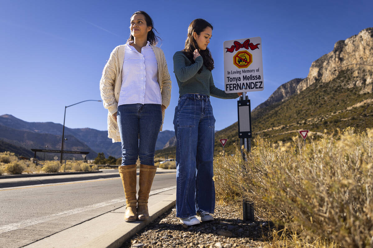 Angela Fernandez, right, with her mom, Maria Fernandez, reacts after placing a sign bearing the ...