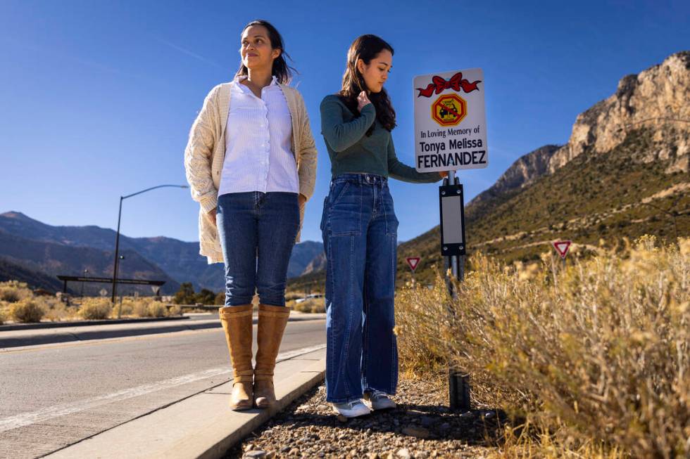 Angela Fernandez, right, with her mom, Maria Fernandez, reacts after placing a sign bearing the ...