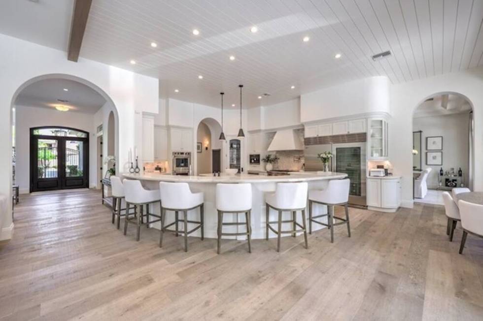 The kitchen features a rounded central island with seating. (Premier Realty Group)