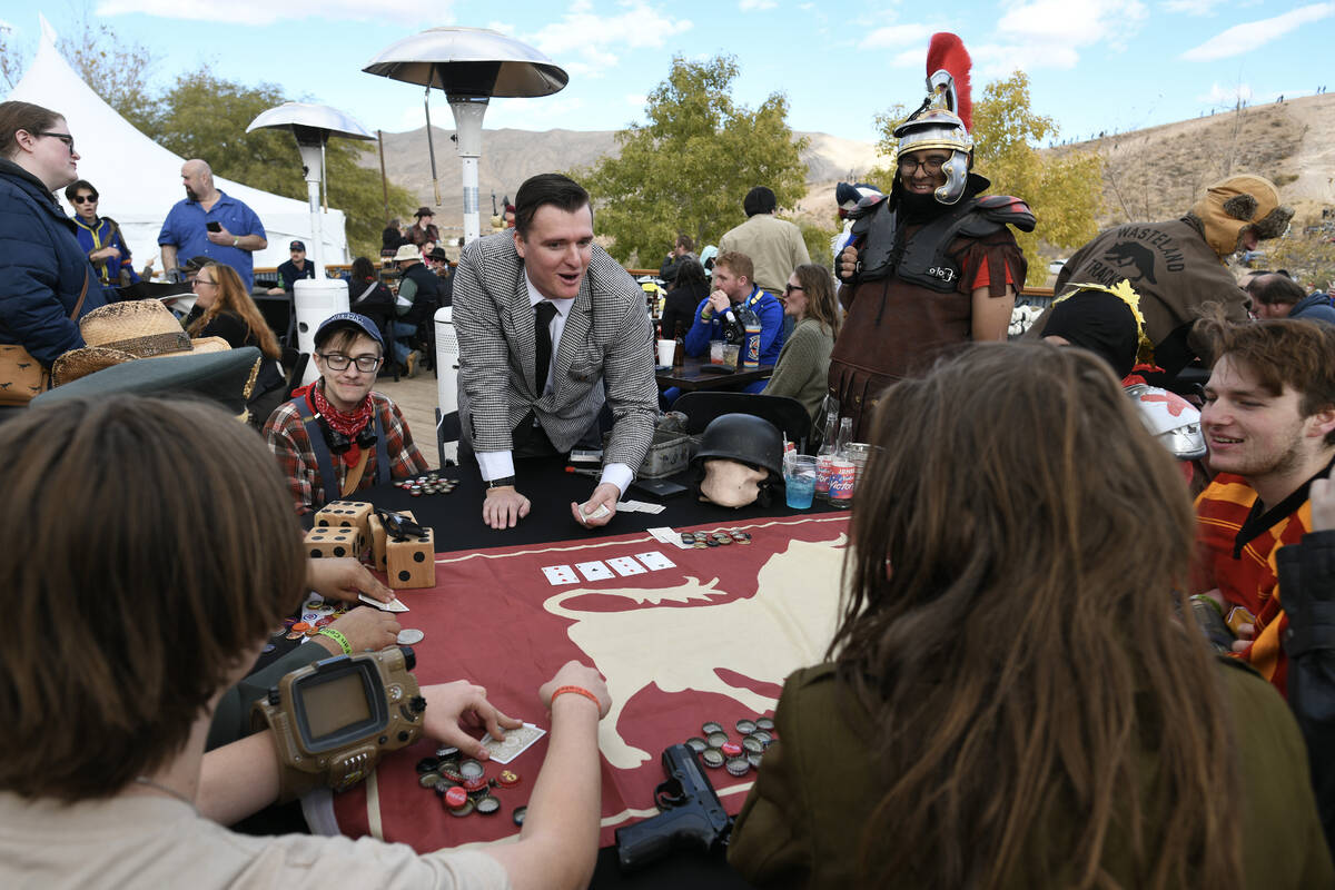 Attendees play cards for bottle caps during the Fallout Fan Celebration Saturday, November 16, ...