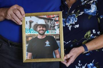 George Paprotny and his wife, Aimee, pose for a portrait as they hold a photo of their son Step ...