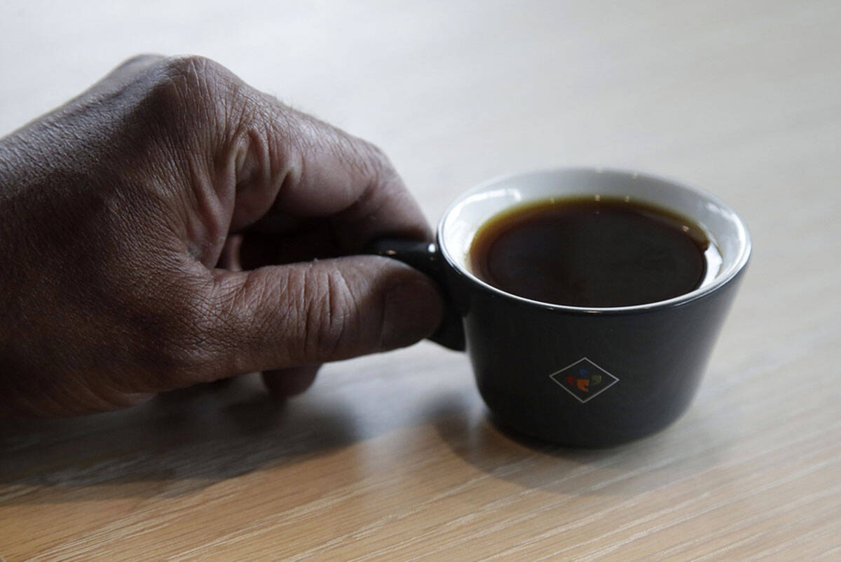 A man holds a cup of coffee in this AP file photo. (AP Photo/Jeff Chiu)