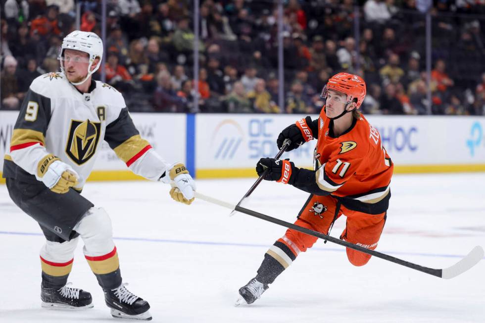 Anaheim Ducks center Trevor Zegras, right, watches his shot next to Vegas Golden Knights center ...