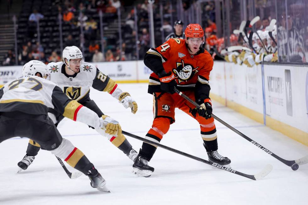 Anaheim Ducks defenseman Pavel Mintyukov, right, vies for the puck against Vegas Golden Knights ...