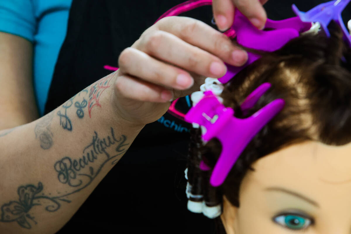 Lishae Macfield practices a perm during a cosmetology class at Florence McClure Women’s ...