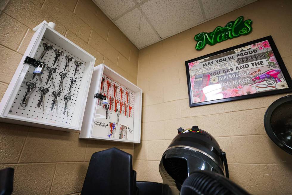 Scissors for cutting hair are seen inside of locked boxes in a classroom during a cosmetology c ...