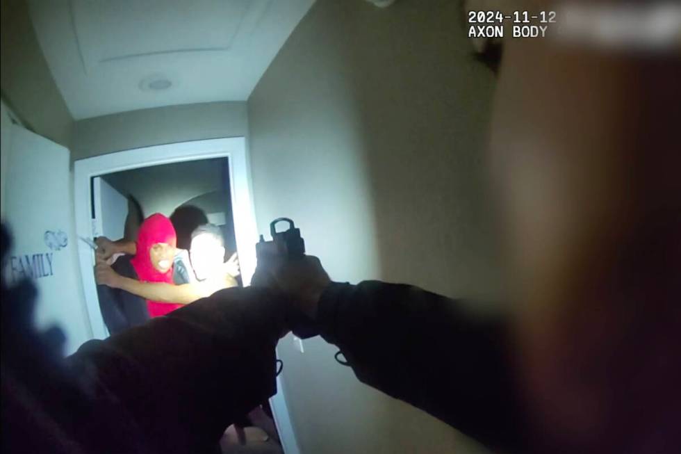 In a body-worn camera photo provided by Metro, an intruder, left, and homeowner Brandon Durham ...