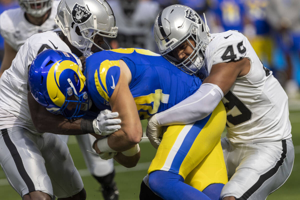 Raiders defensive end Charles Snowden (49) and cornerback Jakorian Bennett (0) tackle Los Angel ...