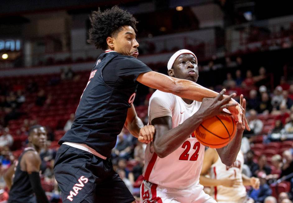 Omaha Mavericks guard Lance Waddles, left, swats the ball from UNLV forward Pape N'Diaye (22) d ...