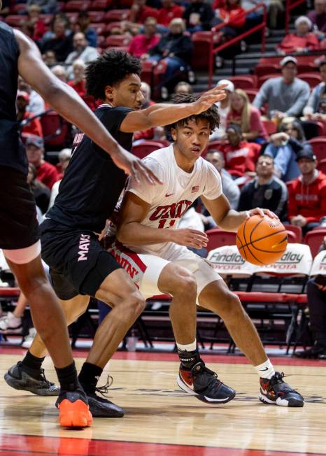 UNLV guard Dedan Thomas Jr. (11) attempts to dribble around Omaha Mavericks guard Lance Waddles ...