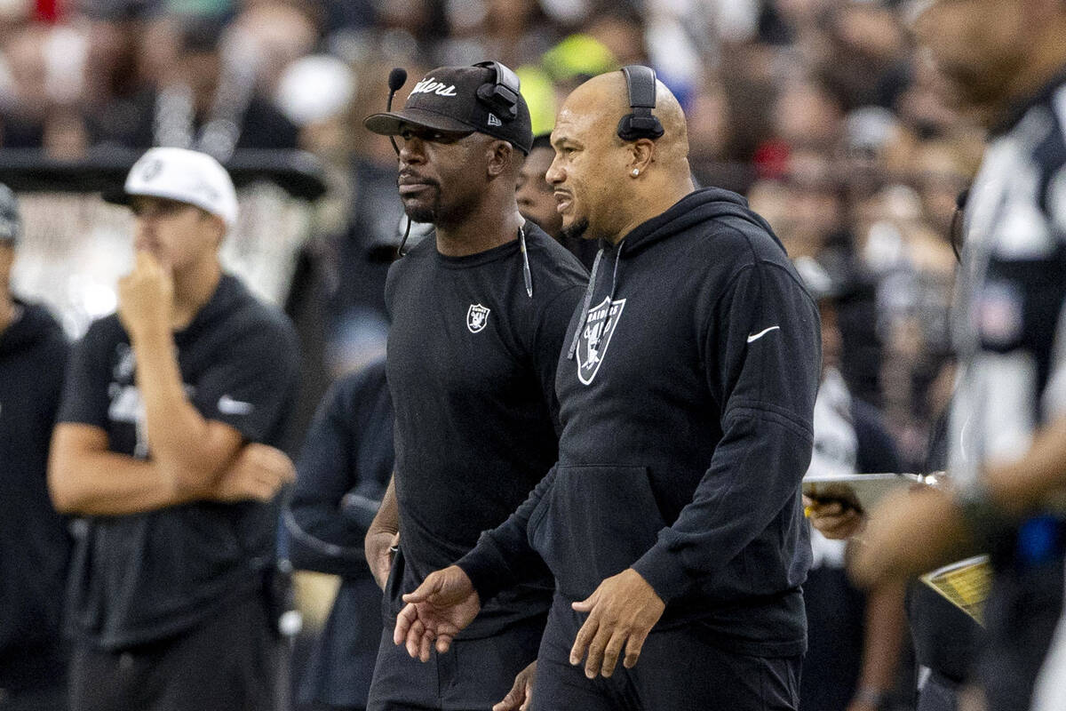 Raiders safeties coach Gerald Alexander and head coach Antonio Pierce interact on the sideline ...