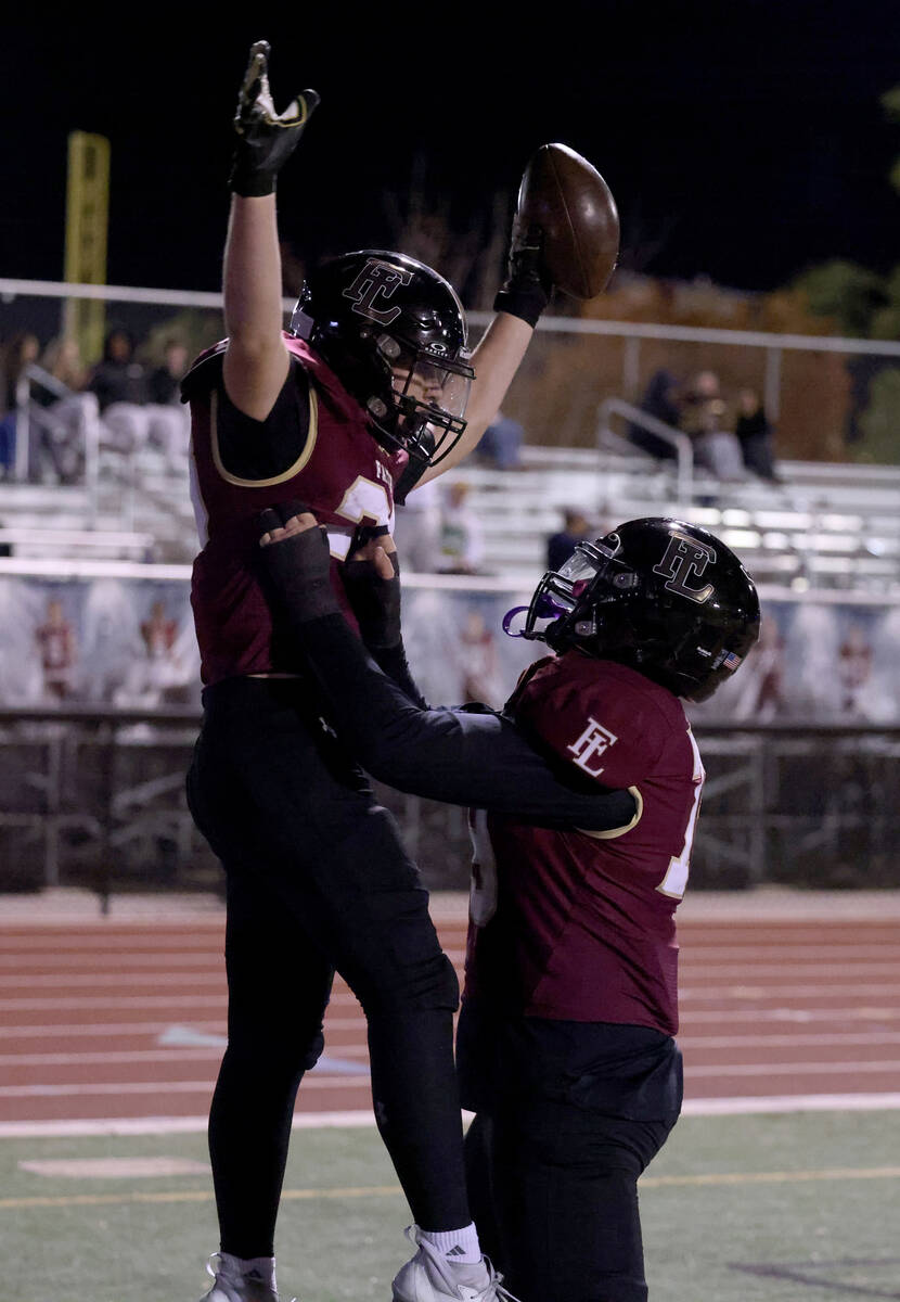 Faith Lutheran running back Justin Robbins (33) celebrates a touchdown with offensive lineman J ...