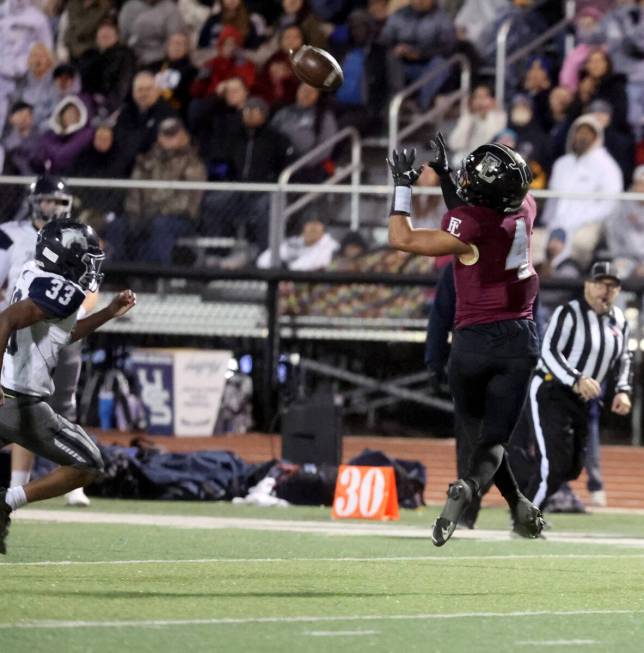 Faith Lutheran wide receiver Rouselle Shepard (4) catches a pass in front of Shadow Ridge safet ...