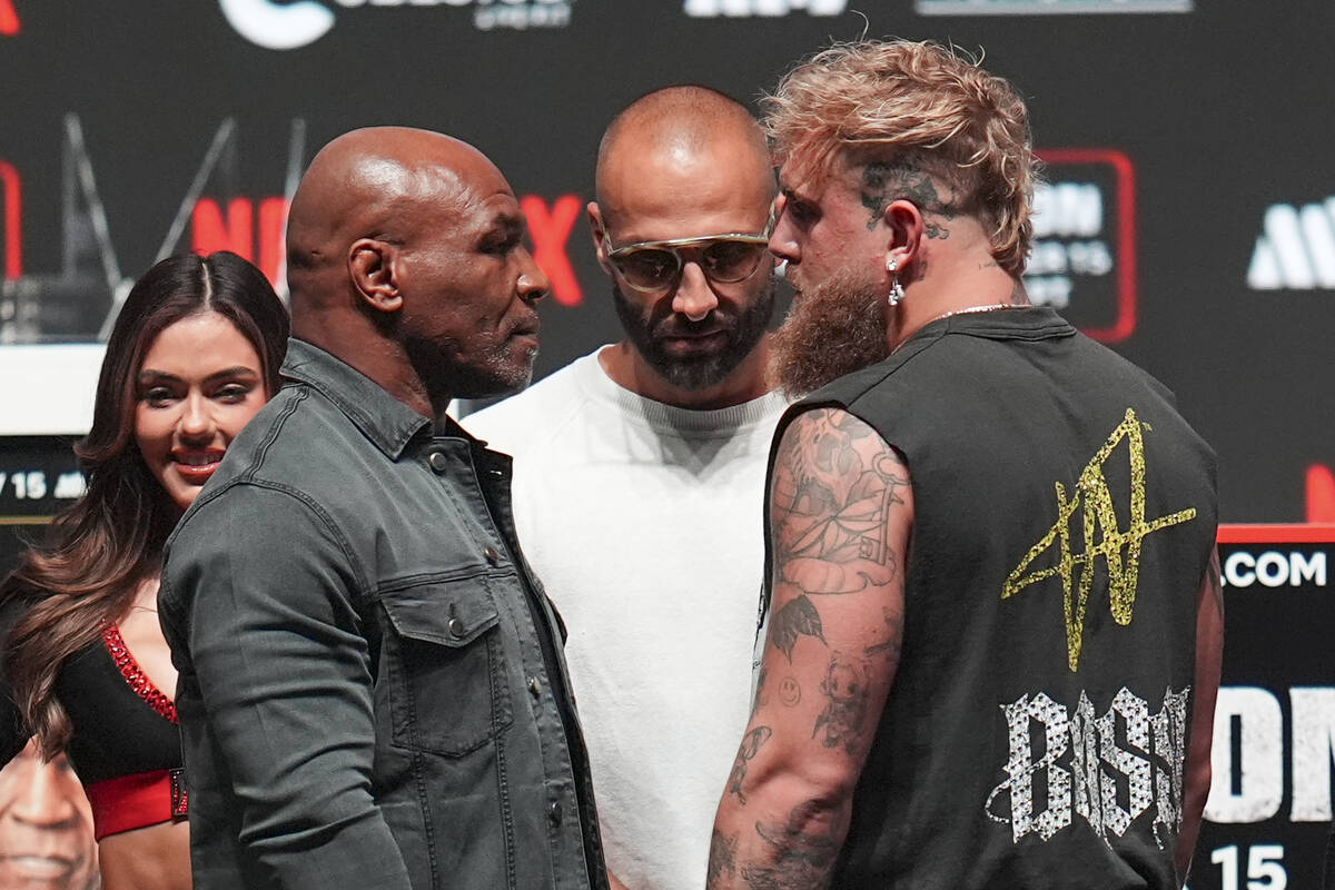 Mike Tyson, front left, and Jake Paul, front right, face off during a news conference ahead of ...