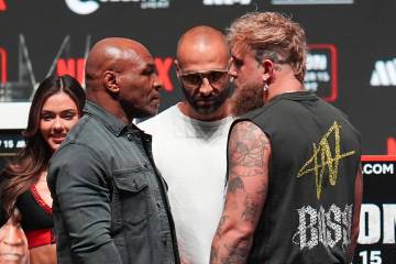 Mike Tyson, front left, and Jake Paul, front right, face off during a news conference ahead of ...