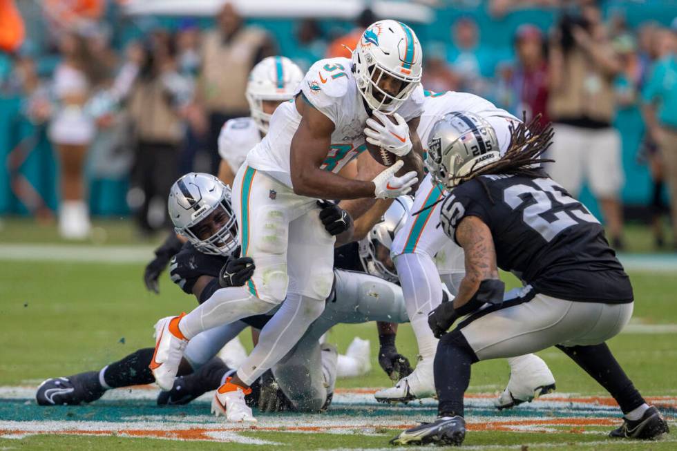 Raiders linebacker Divine Deablo (5) tries to bring down Miami Dolphins running back Raheem Mos ...