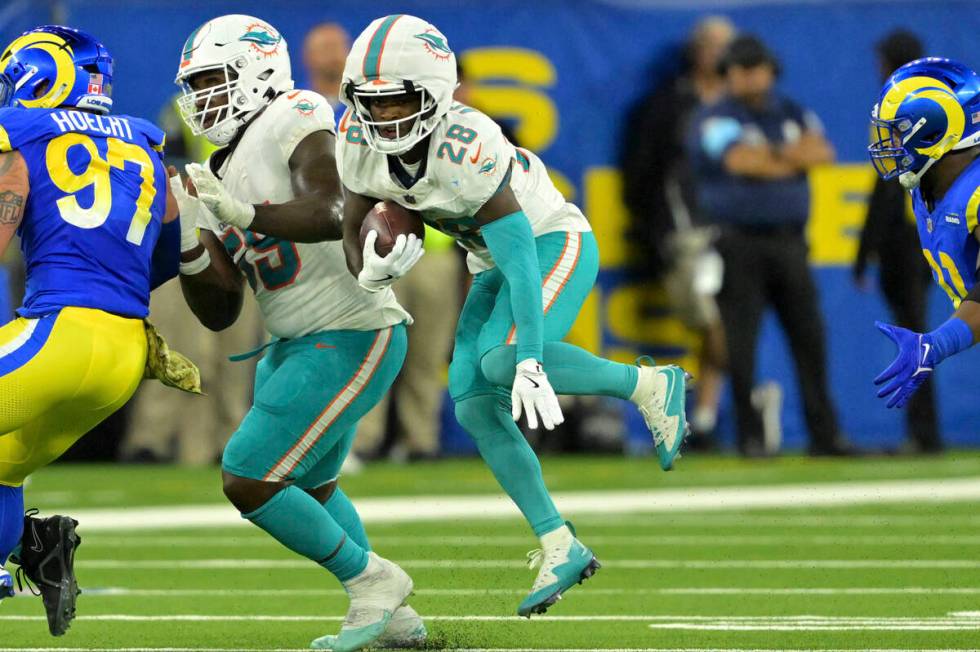 Miami Dolphins running back De'Von Achane (28) carries the ball during an NFL football game aga ...