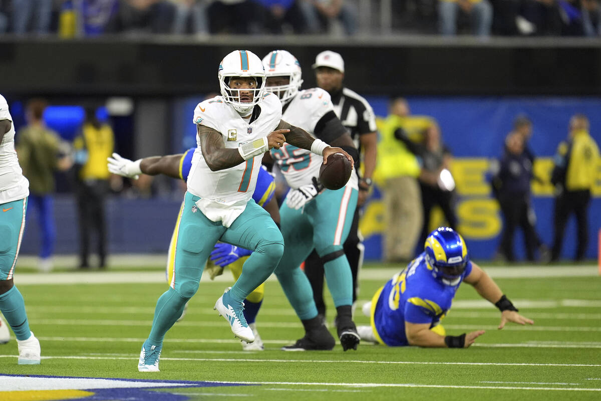 Miami Dolphins quarterback Tua Tagovailoa scrambles during the first half of an NFL football ga ...