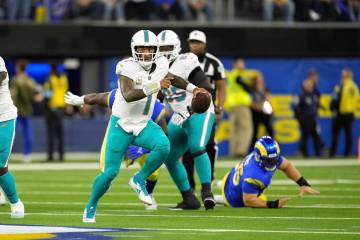 Miami Dolphins quarterback Tua Tagovailoa scrambles during the first half of an NFL football ga ...